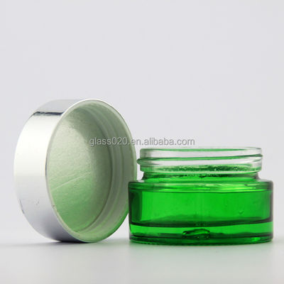 O vidro de creme verde vazio range 5g-100g com a tampa de prata para o cosmético